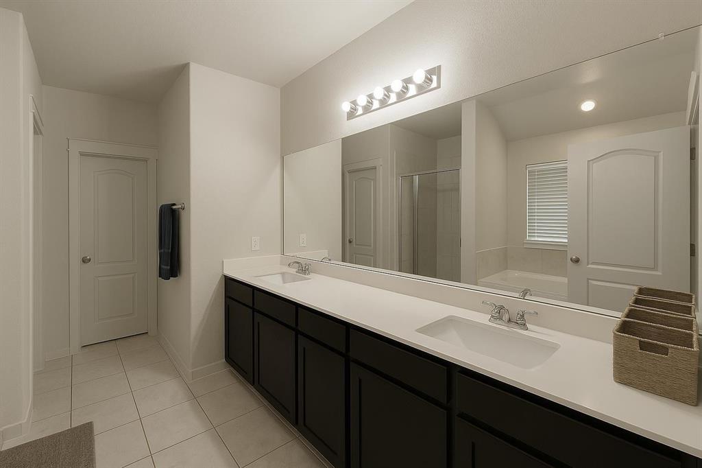 5641 Durst Lane Forney, TX 75126 - Photo 7 of 10 Double vanity with integrated rectangular sinks, white countertops, and dark wood-finish cabinetry