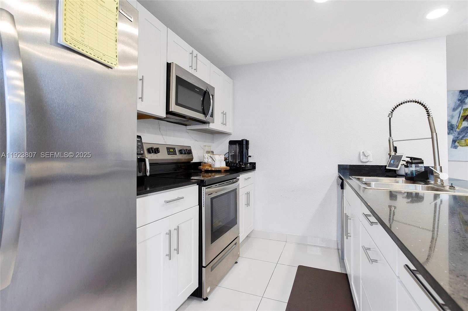 25872 Southwest 139th Path Homestead, FL 33032 - Photo 11 of 51 a kitchen with stainless steel appliances granite countertop a sink and a microwave