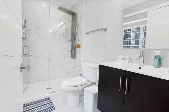 a bathroom with a sink toilet a mirror and shower