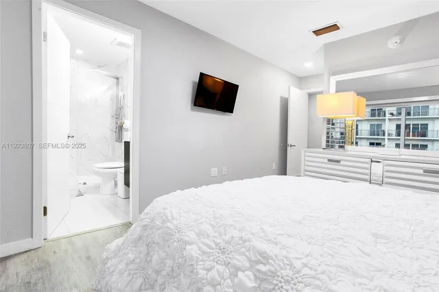 a bedroom with a bed and a flat screen tv