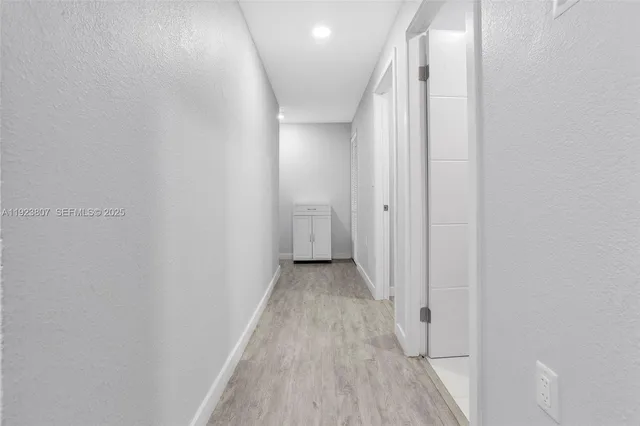 a view of a hallway with wooden floor