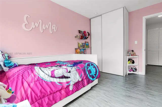 a bedroom with a bed and a wooden floor