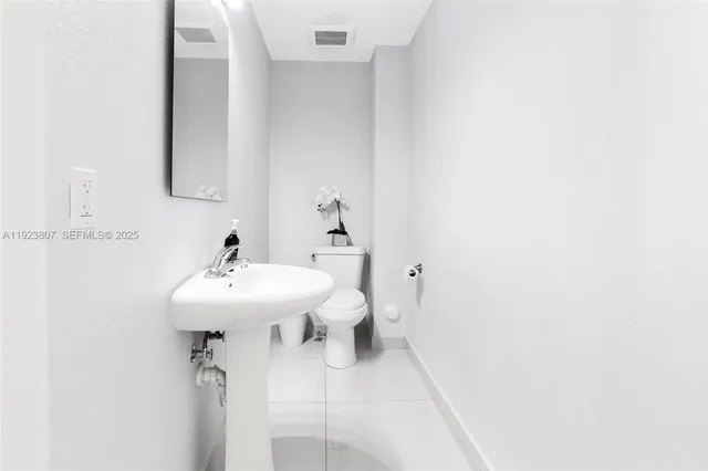a bathroom with a sink a toilet and mirror