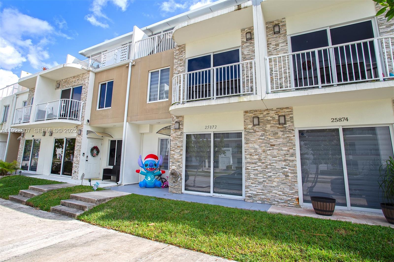 25872 Southwest 139th Path Homestead, FL 33032 - Photo 5 of 51 a view of brick building with many windows and a yard