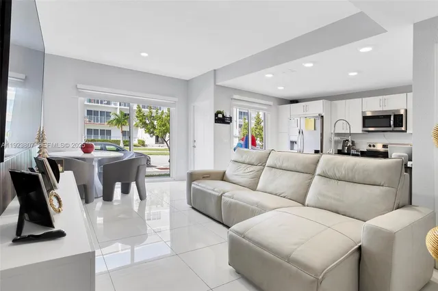 a living room with furniture a flat screen tv and a large window