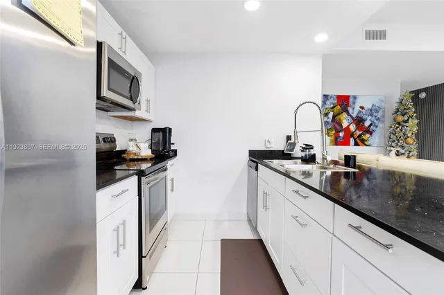 a kitchen with stainless steel appliances granite countertop a sink and cabinets