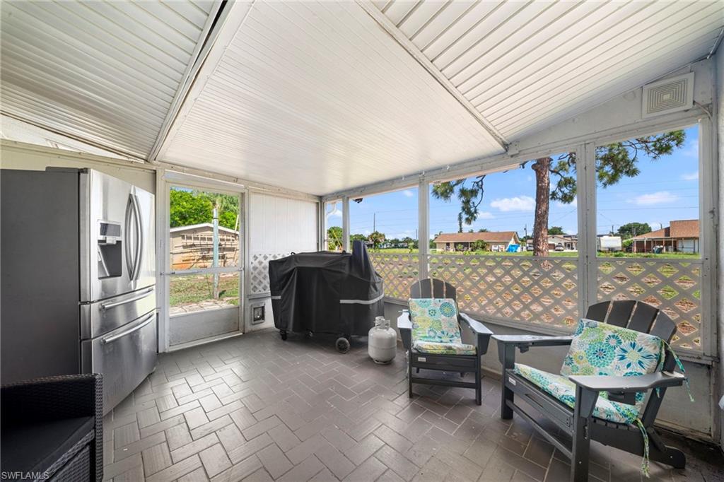 7289 Barragan Road Fort Myers, FL 33967 - Photo 17 of 18 Screened patio featuring herringbone-patterned tile flooring, a slatted ceiling, and an exterior door