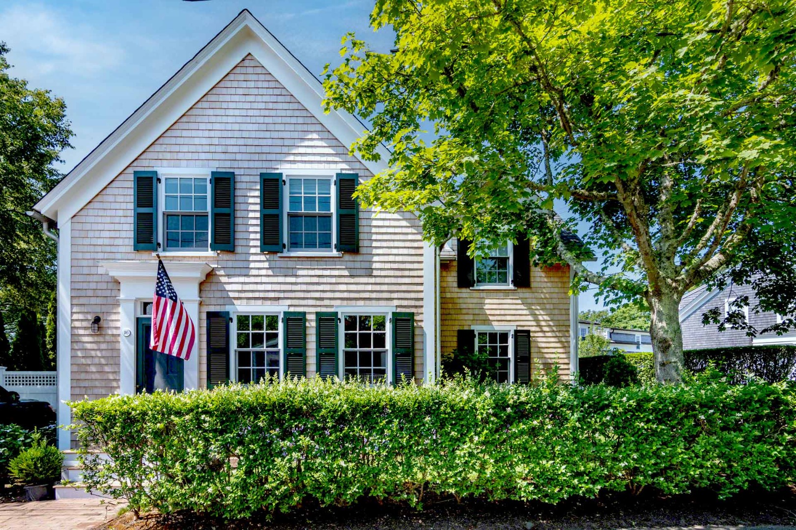 16 Mill Street Edgartown, MA 02539 - Photo 1 of 42 a view of a house with large windows and a small yard