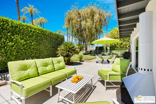 a view of backyard with outdoor seating and plants
