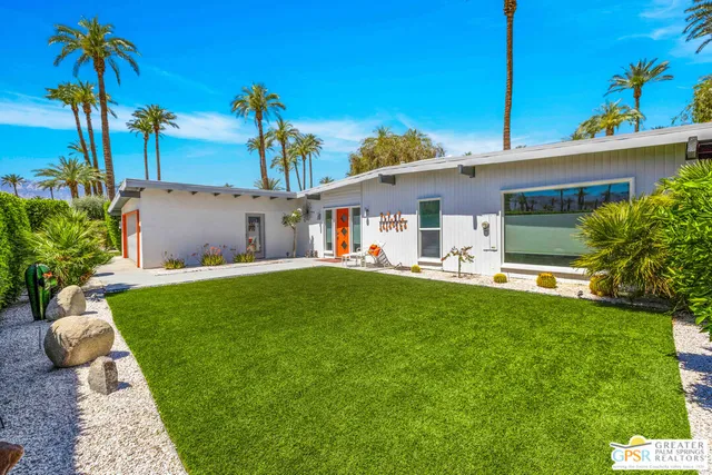 a front view of a house with a garden and yard