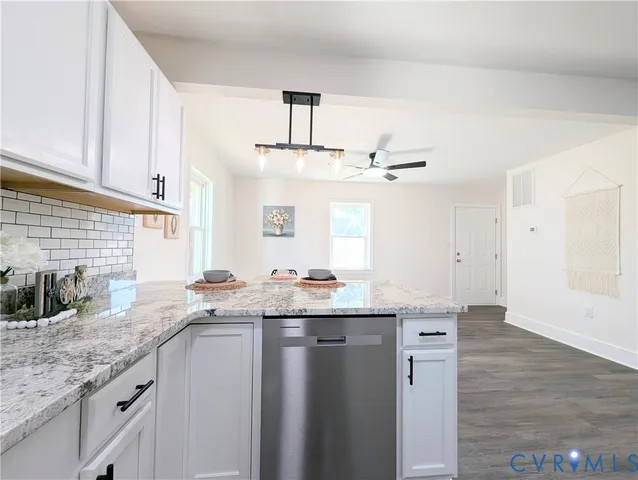 a kitchen with stainless steel appliances granite countertop a sink a stove counter space and cabinets