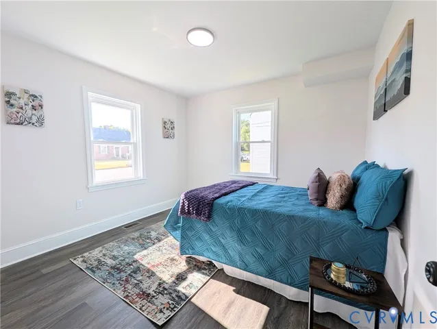 a bedroom with a bed lamp on the dresser and a window
