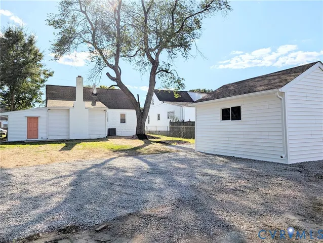 a view of a house with backyard and tree