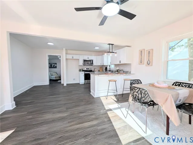 a kitchen with stainless steel appliances kitchen island granite countertop a stove and a refrigerator