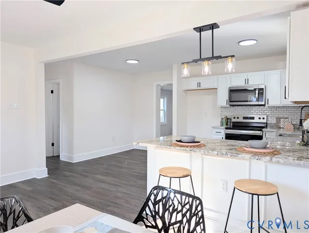 a kitchen with stainless steel appliances kitchen island granite countertop a sink and a stove