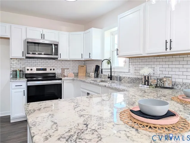 a kitchen with a stove a sink and a microwave