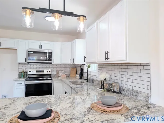 a kitchen with granite countertop a sink a stove and cabinets