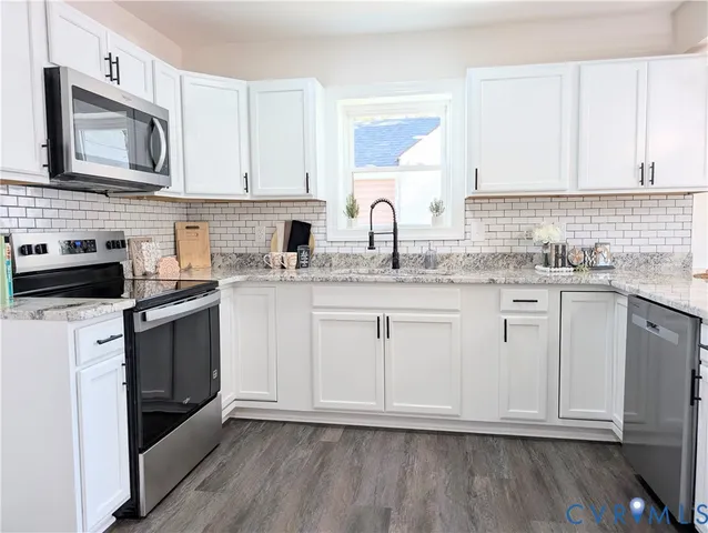 a kitchen with stainless steel appliances granite countertop a sink a stove a microwave and cabinets