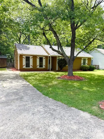 a front view of a house with a yard and trees