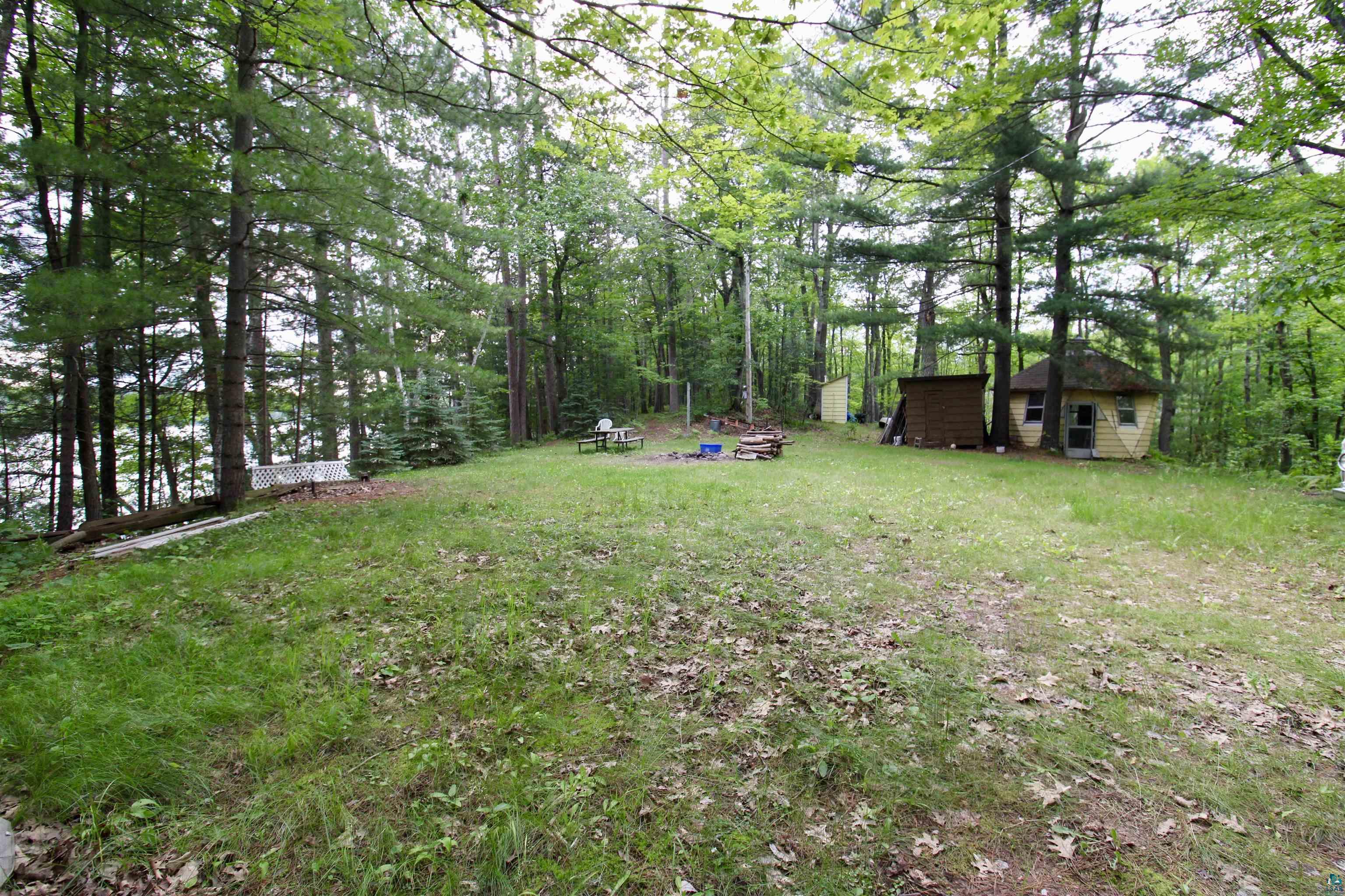 7621 White Beach Road Hayward, WI 54843 - Photo 10 of 26 View of yard with an outdoor structure and a wooded view