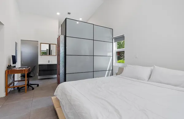 a bedroom with a bed and a potted plant