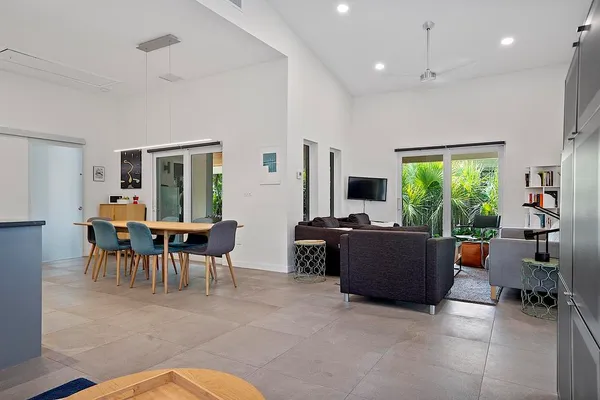 a kitchen with stainless steel appliances kitchen island granite countertop a table chairs in it and a window