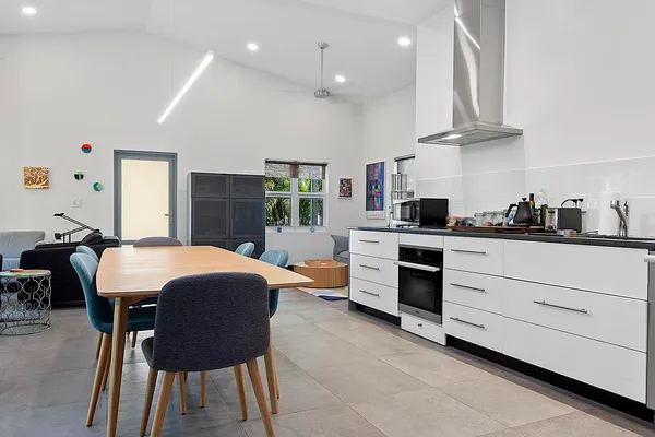 a kitchen with stainless steel appliances kitchen island granite countertop a sink a stove a refrigerator and island with wooden floor