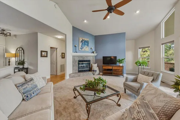 a living room with furniture a large window and a fireplace