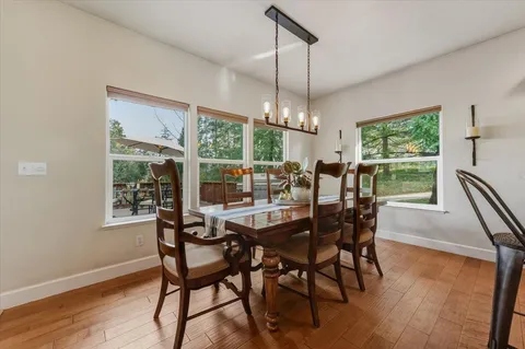 a kitchen with stainless steel appliances kitchen island granite countertop a stove a sink and a wooden floors