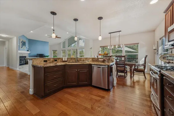 a kitchen with granite countertop wooden cabinets and a stove top oven