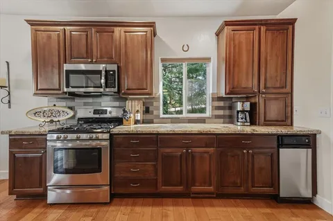a kitchen with stainless steel appliances granite countertop a refrigerator and a sink