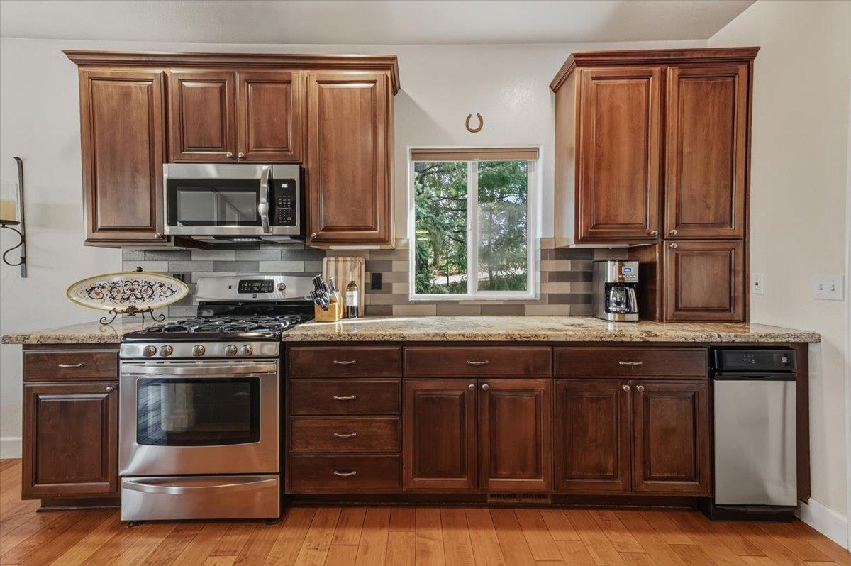 16041 John Way Grass Valley, CA 95949 - Photo 22 of 56 a kitchen with granite countertop wooden cabinets and a stove top oven