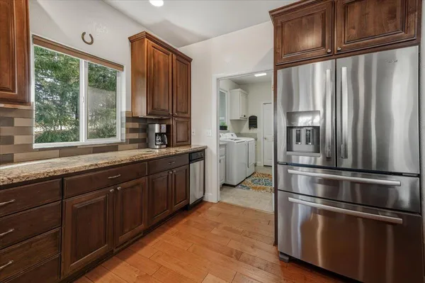 a view of a hallway with wooden floor and closet