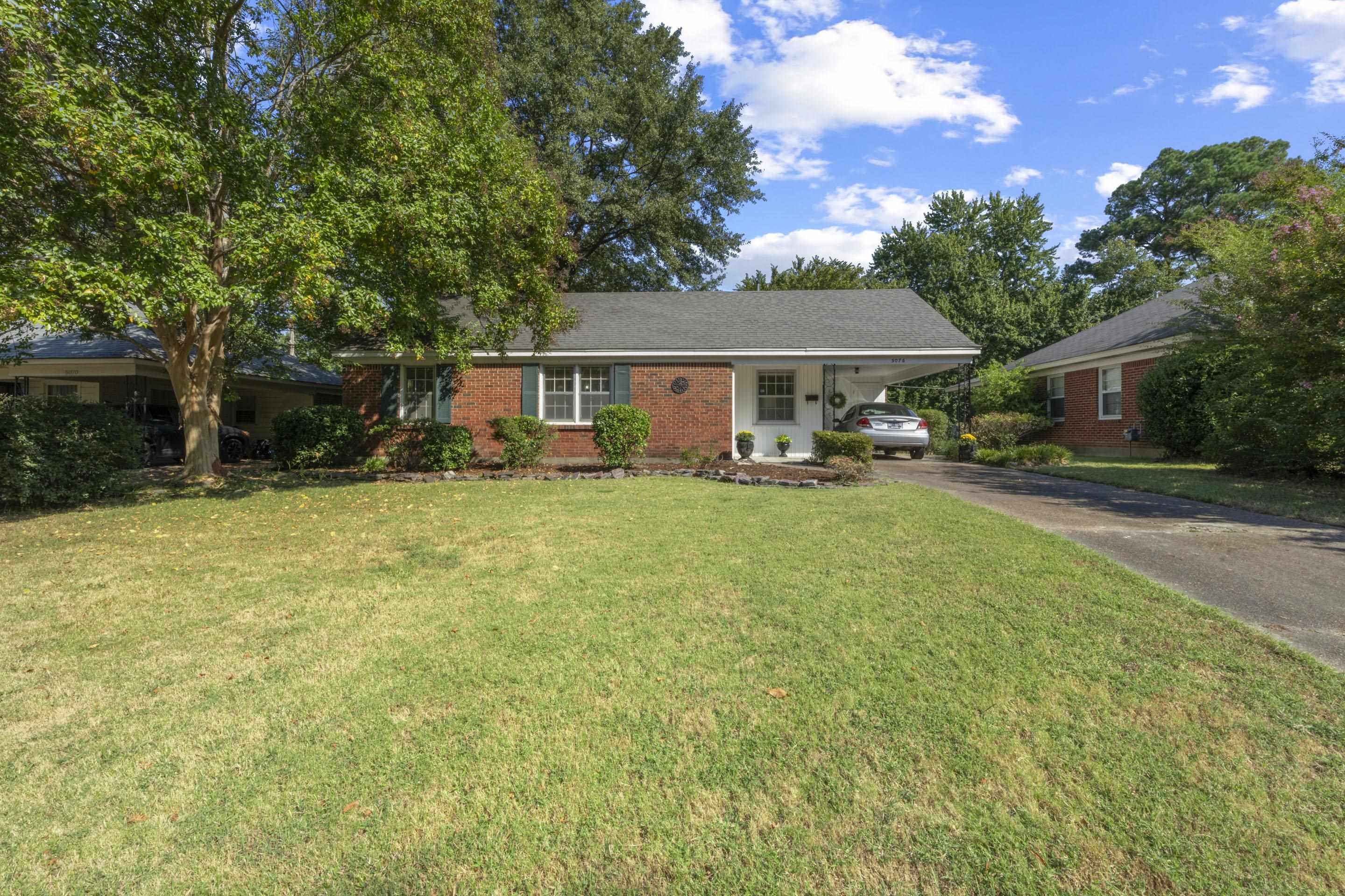 a view of a house with a big yard and sitting area