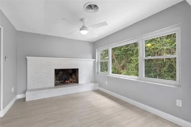 an empty room with windows and a fireplace