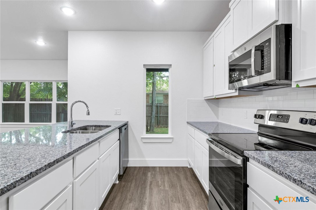 1904 Royal Loop Belton, TX 76513 - Photo 6 of 13 a kitchen with stainless steel appliances granite countertop a sink stove and microwave