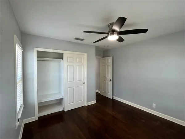 a view of empty room with wooden floor