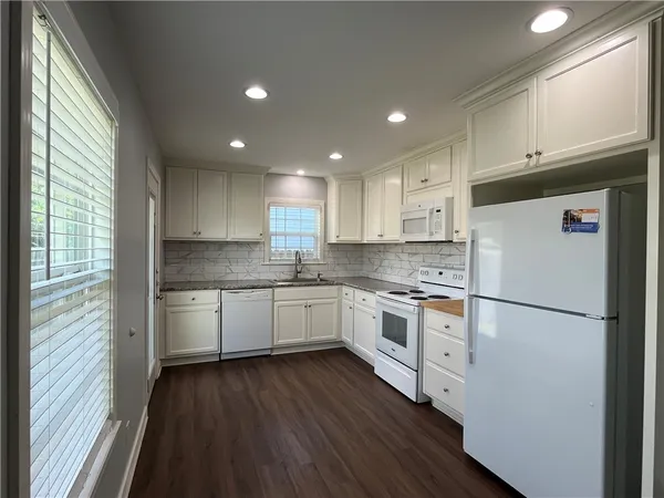 a kitchen with a refrigerator a sink and cabinets