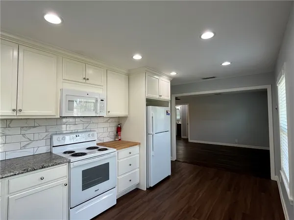 a kitchen with refrigerator and cabinets