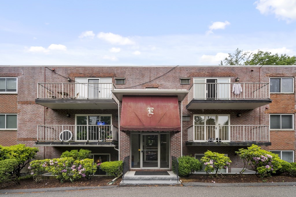a front view of a residential apartment building with a yard