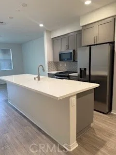 a kitchen with stainless steel appliances a sink a stove a refrigerator and cabinets