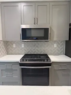 a kitchen with granite countertop white cabinets and black appliances