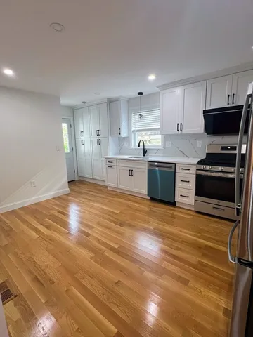 a large kitchen with stainless steel appliances granite countertop a stove and a sink