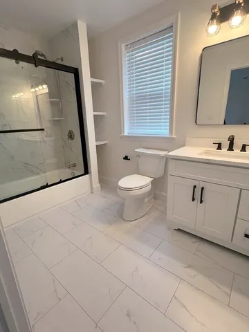 a bathroom with a sink a toilet and mirror