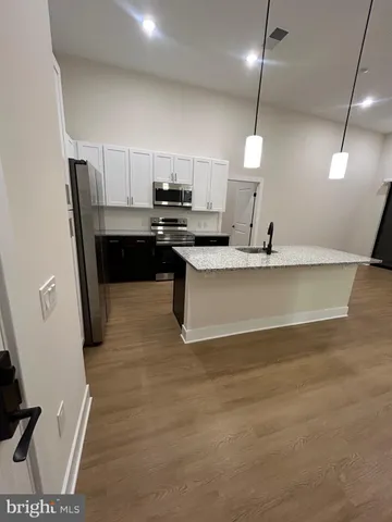 a kitchen with kitchen island a sink appliances and a counter top space