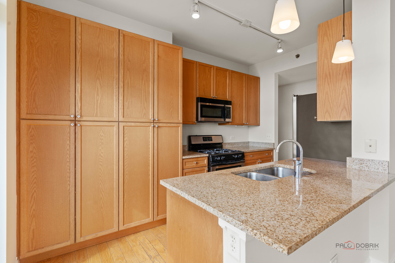1400 South Michigan Avenue, Unit 1404 Chicago, IL 60605 - Photo 8 of 26 a kitchen with granite countertop a sink a counter top space appliances and cabinets