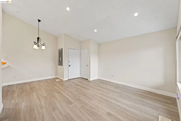 a view of empty room with wooden floor and ceiling fan