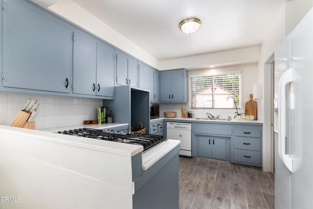 1305 Solita Road Pasadena, CA 91103 - Photo 11 of 33 a kitchen with granite countertop a sink a stove a refrigerator and cabinets