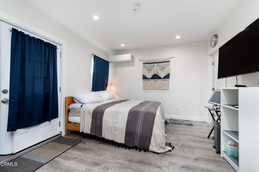 1305 Solita Road Pasadena, CA 91103 - Photo 30 of 33 a spacious bedroom with a bed and a flat screen tv