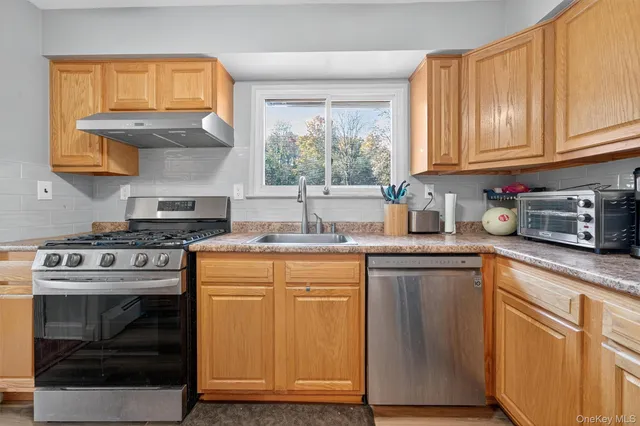 a kitchen with granite countertop wooden cabinets and a stove